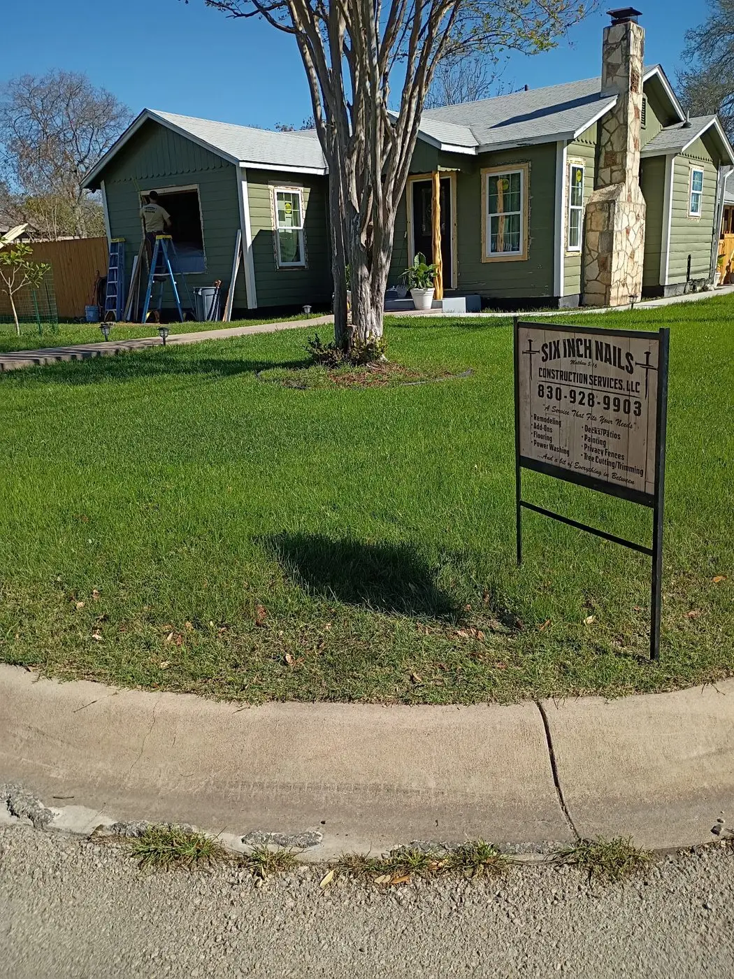 Completed home remodel with fresh siding and a Six Inch Nails yard sign out front