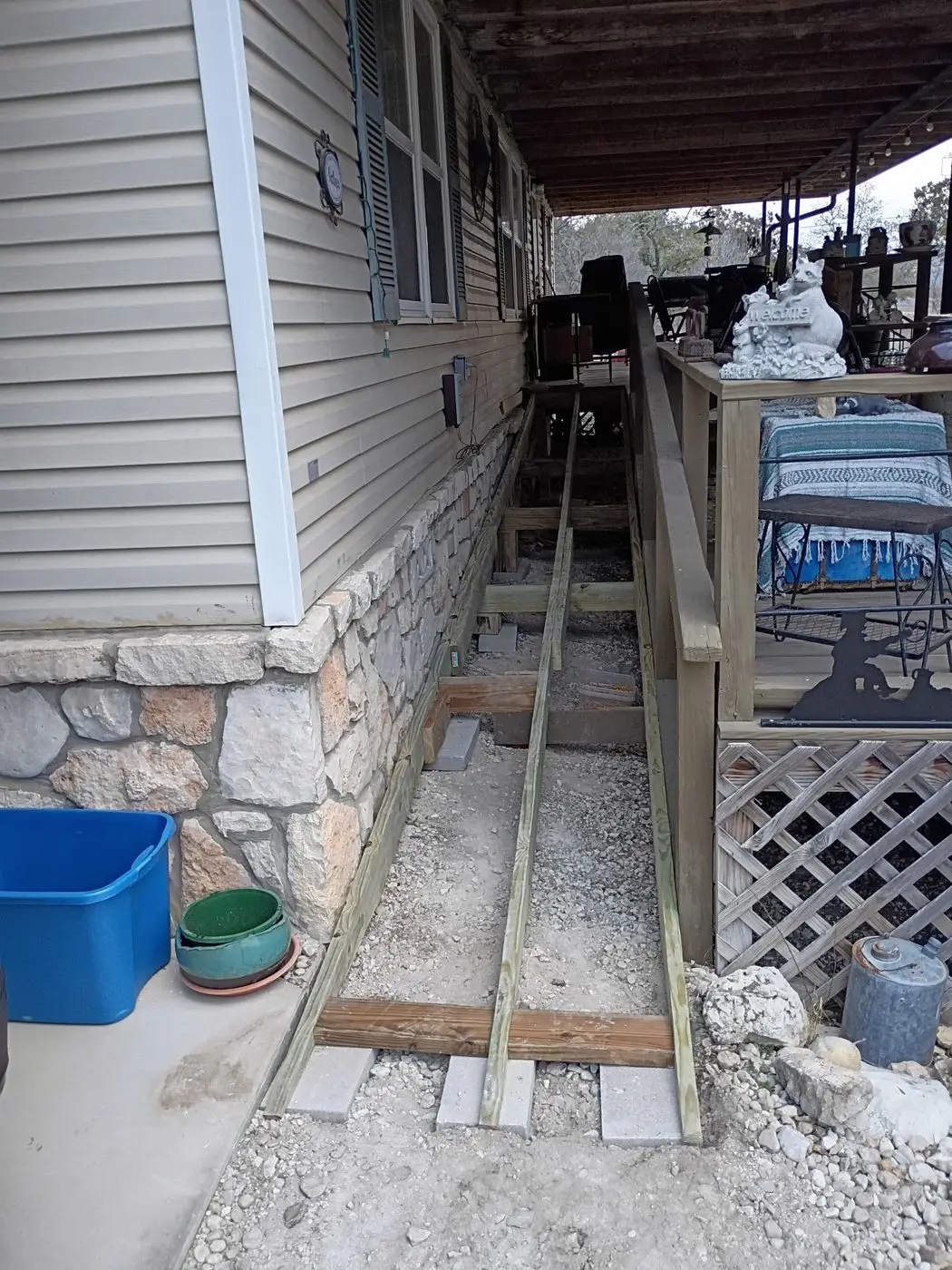 Covered porch rebuild with stone skirting and new support framing
