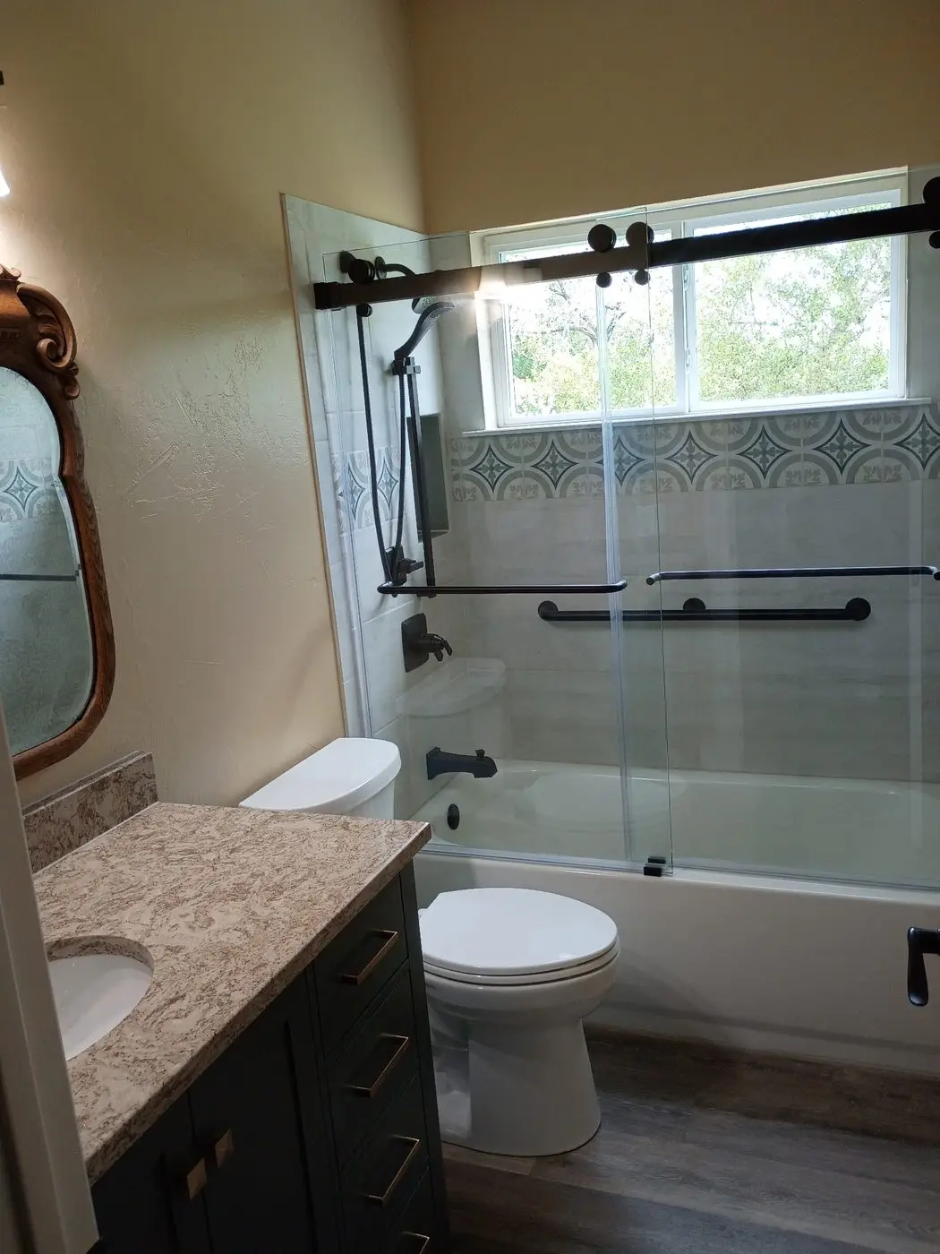 Remodeled bathroom with tiled tub surround and new vanity