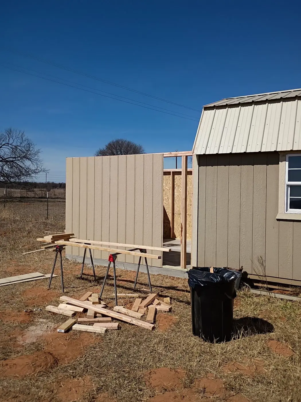 Barn-style building under construction with siding going up